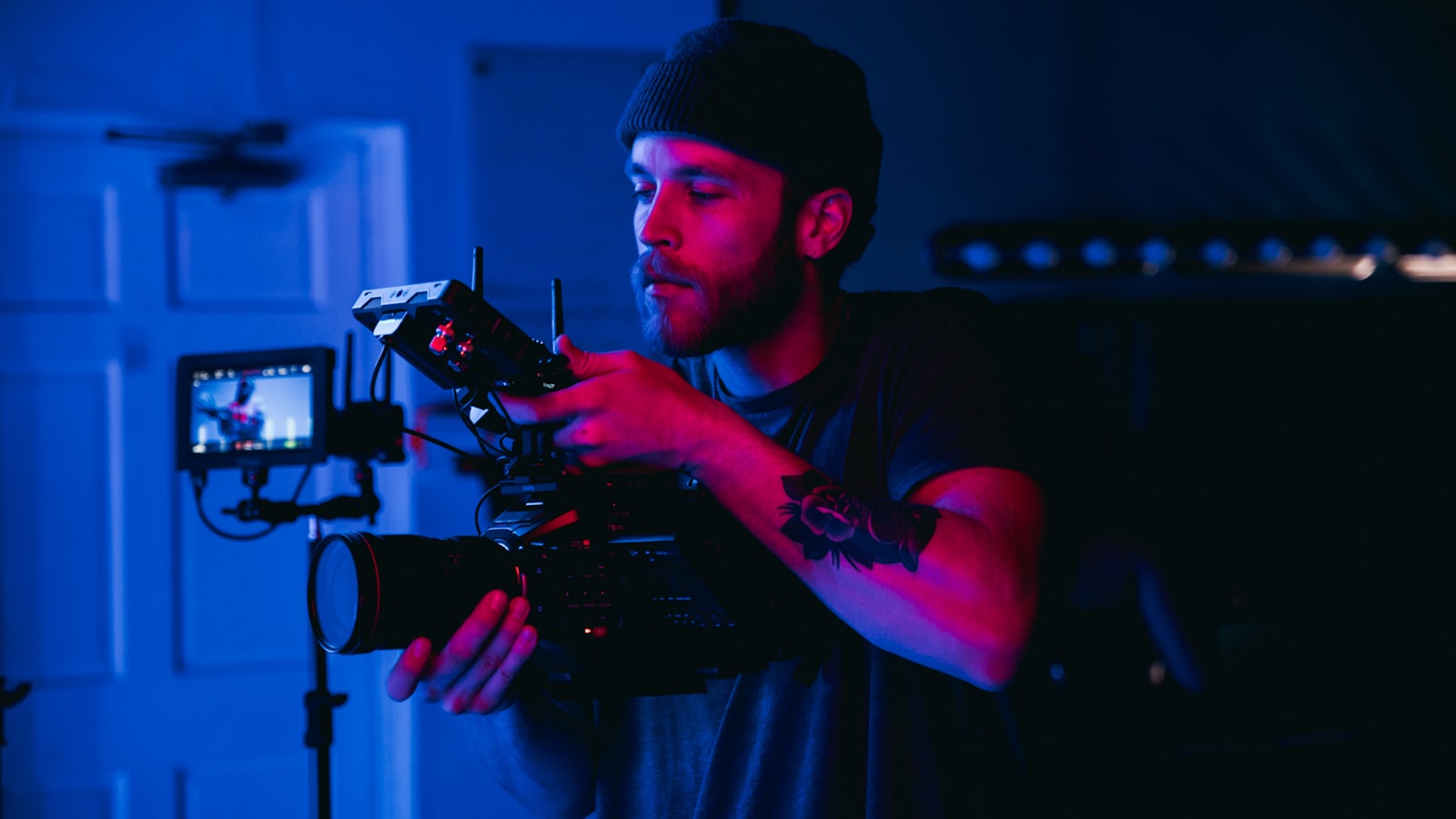 Cadreur réglant sa caméra lors d'un tournage en lumière colorée